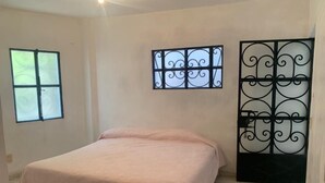 A bedroom with a bed, a window, and a decorative metal gate. - Casa Mila Taxco, pueblo mágico, ubicada en Centro Histórico, cerca de todo a pie (Taxco)