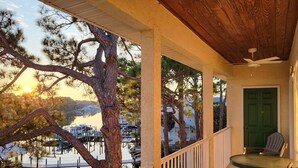 A covered outdoor area with a view of a marina and a green door. - Amazing view of Grand Lagoon and Walk to Beach (Panama City Beach)