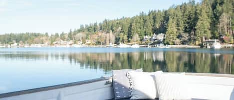Un bateau doté de sièges confortables et offrant une vue sur un lac paisible, bordé d’une rive boisée.