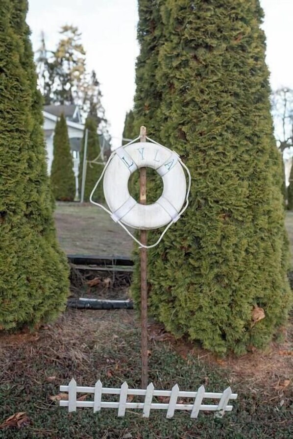 Une bouée de sauvetage attachée à un arbre dans un jardin.