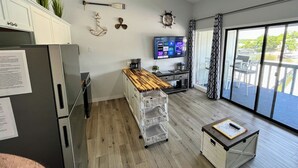 A modern kitchen with a wooden island, stainless steel appliances, and a large window with a view of a body of water. - B Lakefront! Remodeled, Boat Slip, Ramp, Patio Views, Sleeps 4, Pool, Kitchen (Osage Beach)