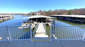 A dock with boats, a covered area, and a clear view of the water. - B Lakefront! Remodeled, Boat Slip, Ramp, Patio Views, Sleeps 4, Pool, Kitchen (Osage Beach)