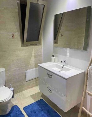 Bathroom features a sink, mirror, toilet, and bathtub.