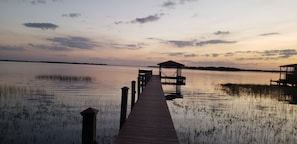 A wooden pier extending into calm water with a gazebo at the end.
