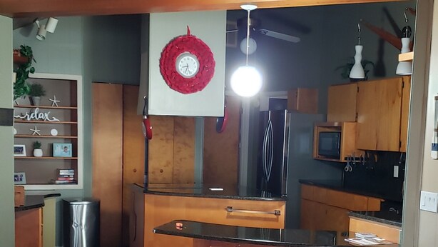 Una cocina moderna con armarios de madera, una isla central y taburetes de bar.