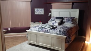 Un dormitorio con cama, mesita de noche y lámpara de pared.