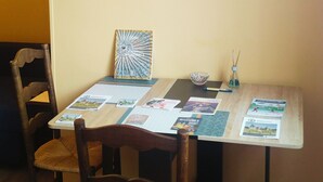 Ein Essbereich mit Tisch für zwei Personen, mit einer gerahmten Himmelskarte an der Wand und einem dekorativen Gegenstand auf dem Tisch.