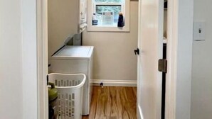 A laundry room with a washing machine, dryer, and a window.