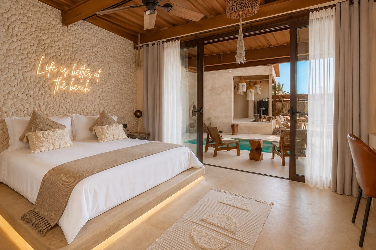 Un dormitorio con una cama grande, vistas a la piscina y un letrero de neón.