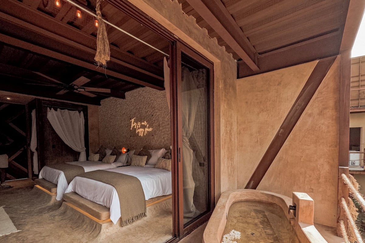 A cozy bedroom with a large bed, a small table, and a bathtub.