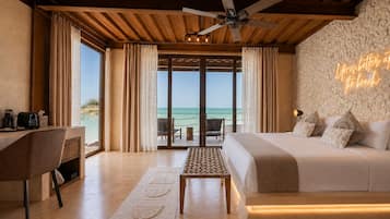 Une chambre d’hôtel avec un lit, un bureau et une vue sur la plage.