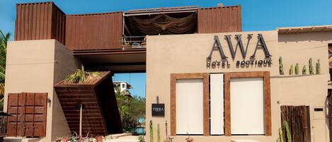 A hotel with a unique architectural design, featuring a prominent sign for 'AWA Hotel Boutique' and a visible pool area.