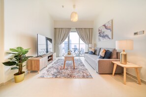 Una sala de estar moderna con un sofá, televisor y una planta en maceta.