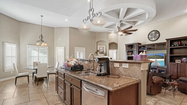 A spacious kitchen with a central island, a dining area with a round table, and a bar area with seating. - Entire Cozy Home in West El Paso (El Paso)