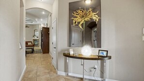 A hallway with a reception desk, a large mirror, and a decorative plant. - Entire Cozy Home in West El Paso (El Paso)