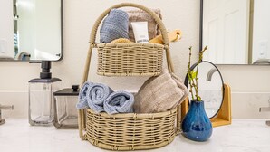 A wicker basket with towels and toiletries on a bathroom counter. - Large recently remodeled home close to Yosemite.  Hot tub, EV, Game room. (Oakhurst)