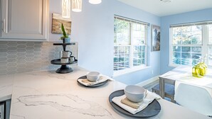 A kitchen with marble countertops, pendant lights, and a window with a view of trees. - Large recently remodeled home close to Yosemite.  Hot tub, EV, Game room. (Oakhurst)