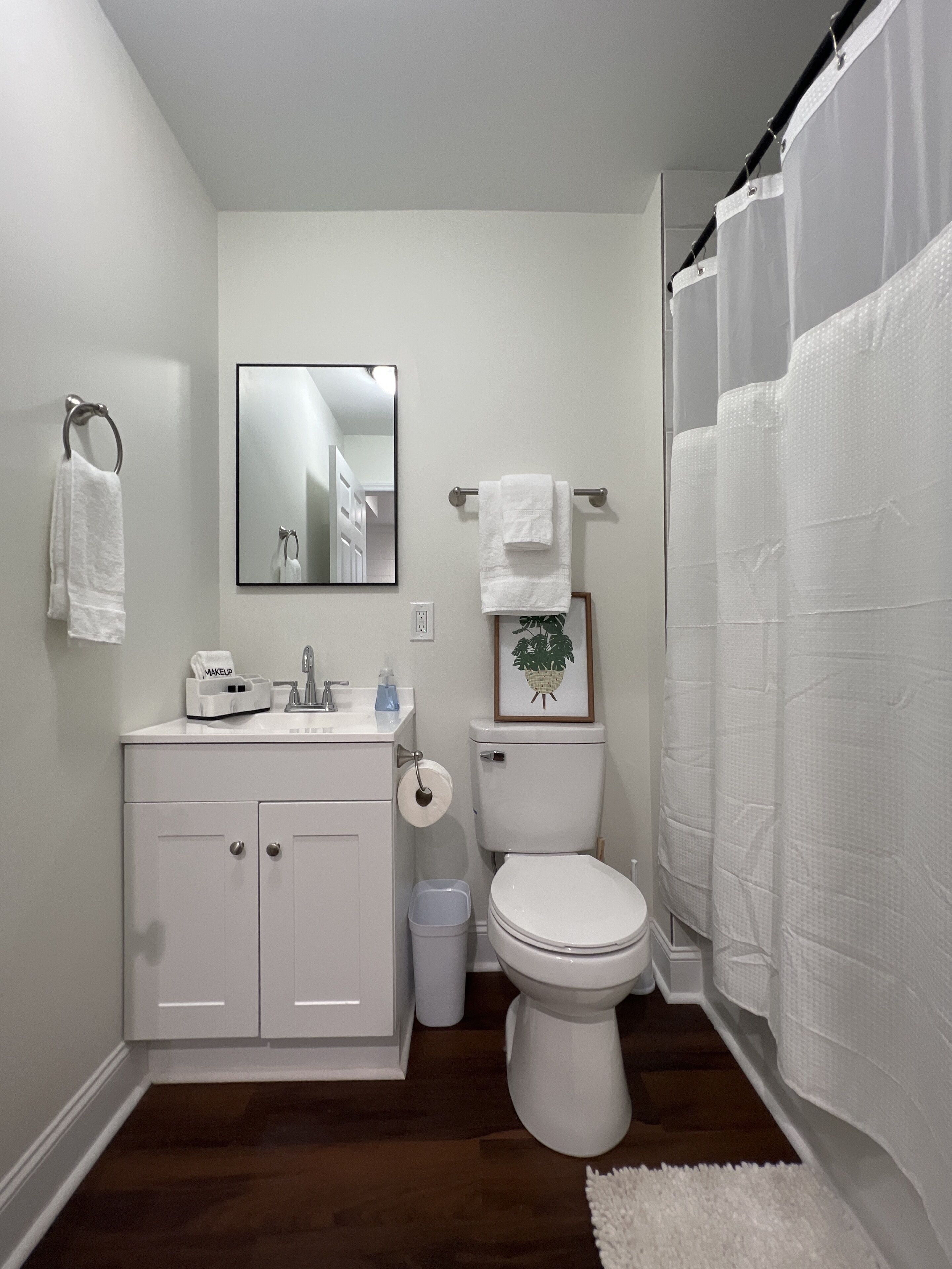 A bathroom with a white sink, toilet, and shower curtain.