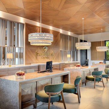 A modern hotel lobby with a reception desk, seating area, and large windows offering views.