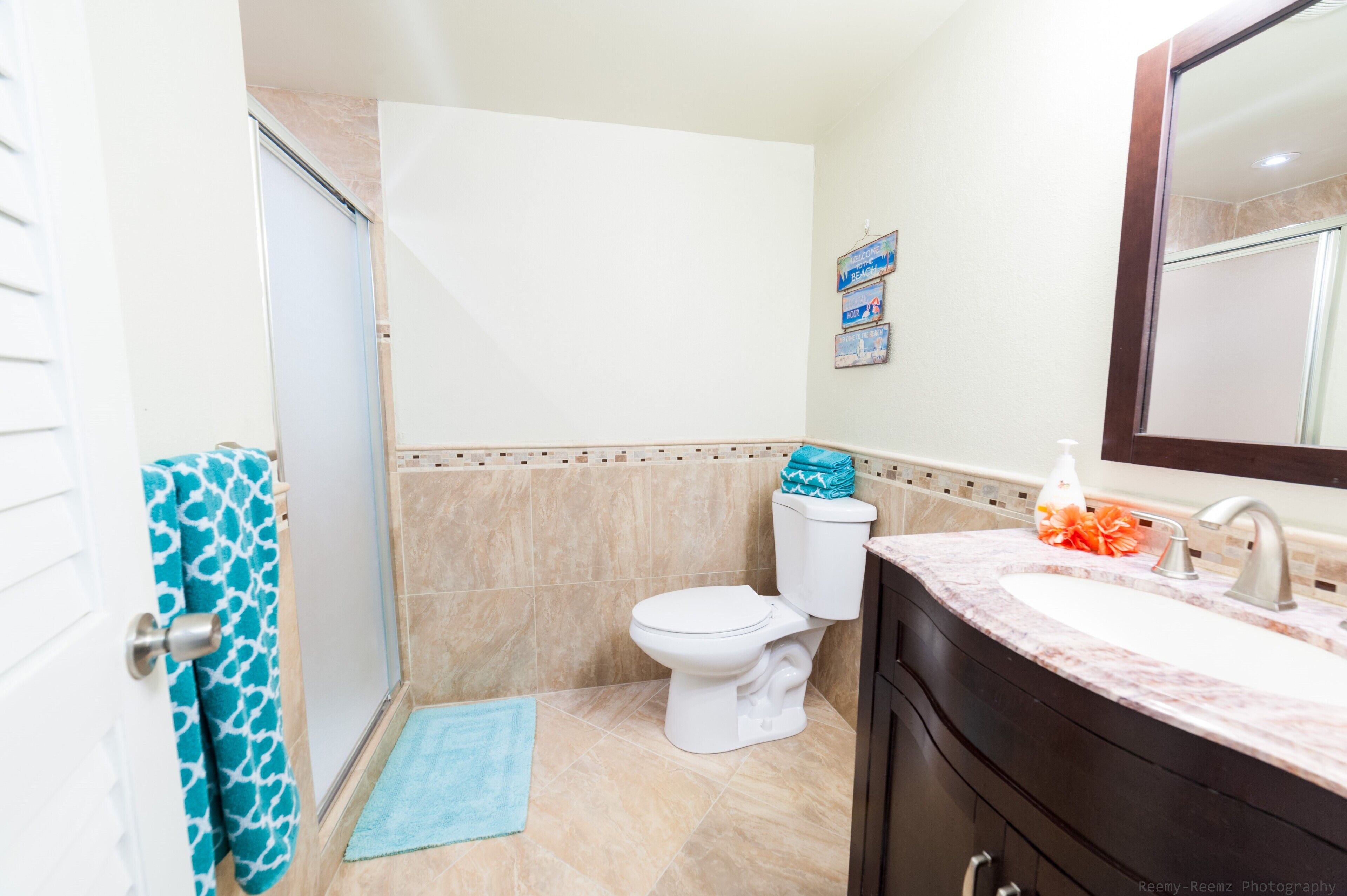 A bathroom with a toilet, sink, and a shower area.