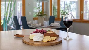 Ett matbord med en ostbricka, vindruvor, kex och ett glas rött vin.