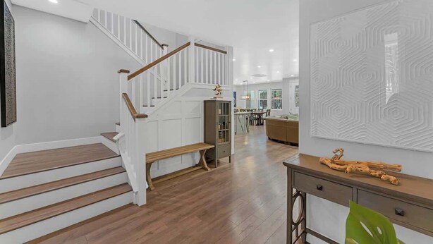 Un interior moderno con escalera de madera, comedor y cocina.