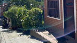 A two-story building with a brick facade, a visible window with bars, and a door marked with the number 22-10. - Chali (Retiro)