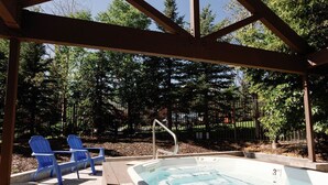 A covered outdoor swimming pool with two blue chairs and a wooden deck. - Modern 2 bed / 2 bath condo with hot tub. 5 min to Skiing and Main St.! (Park City)