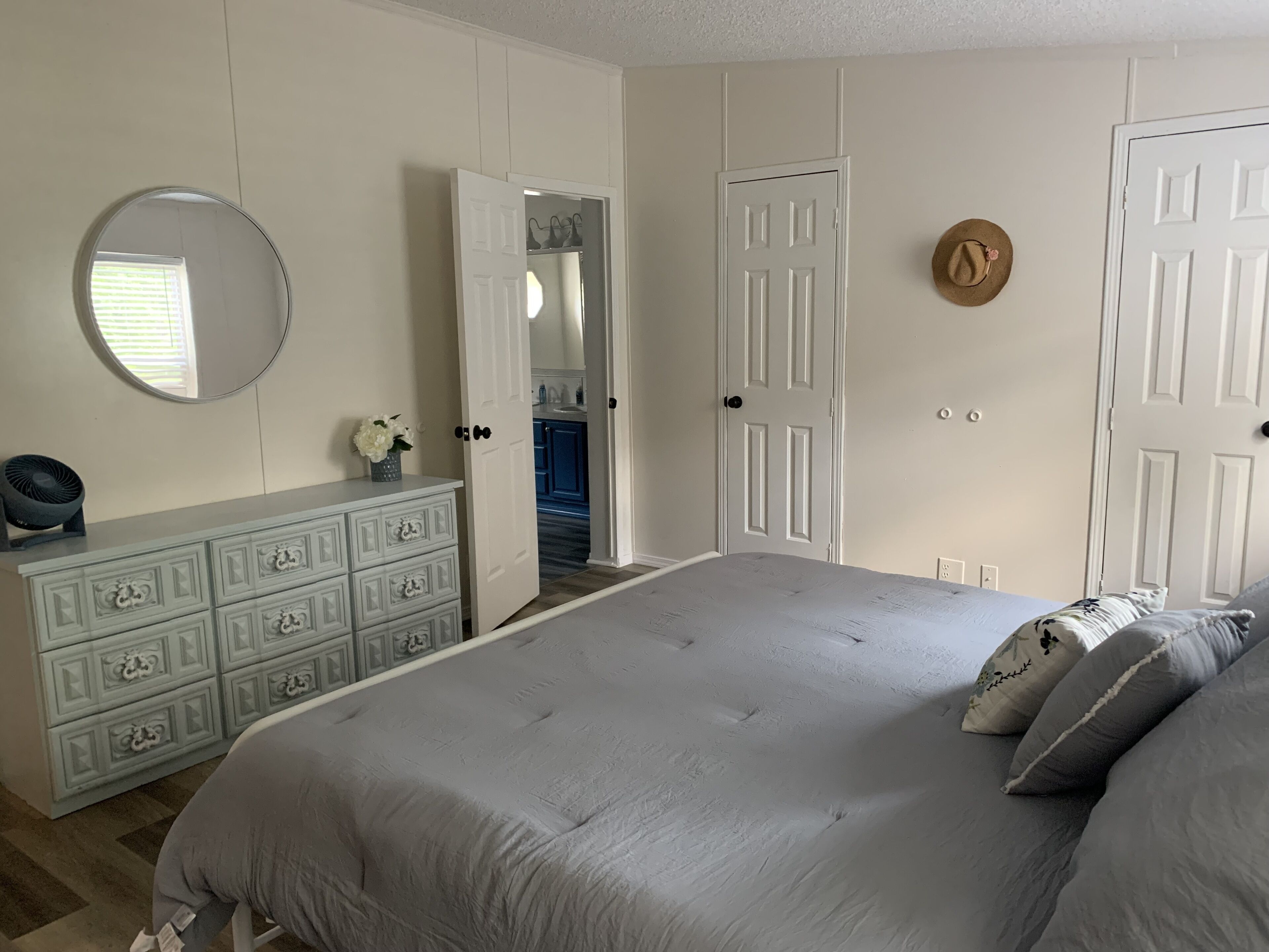 Un dormitorio con cama, cómoda y armario.