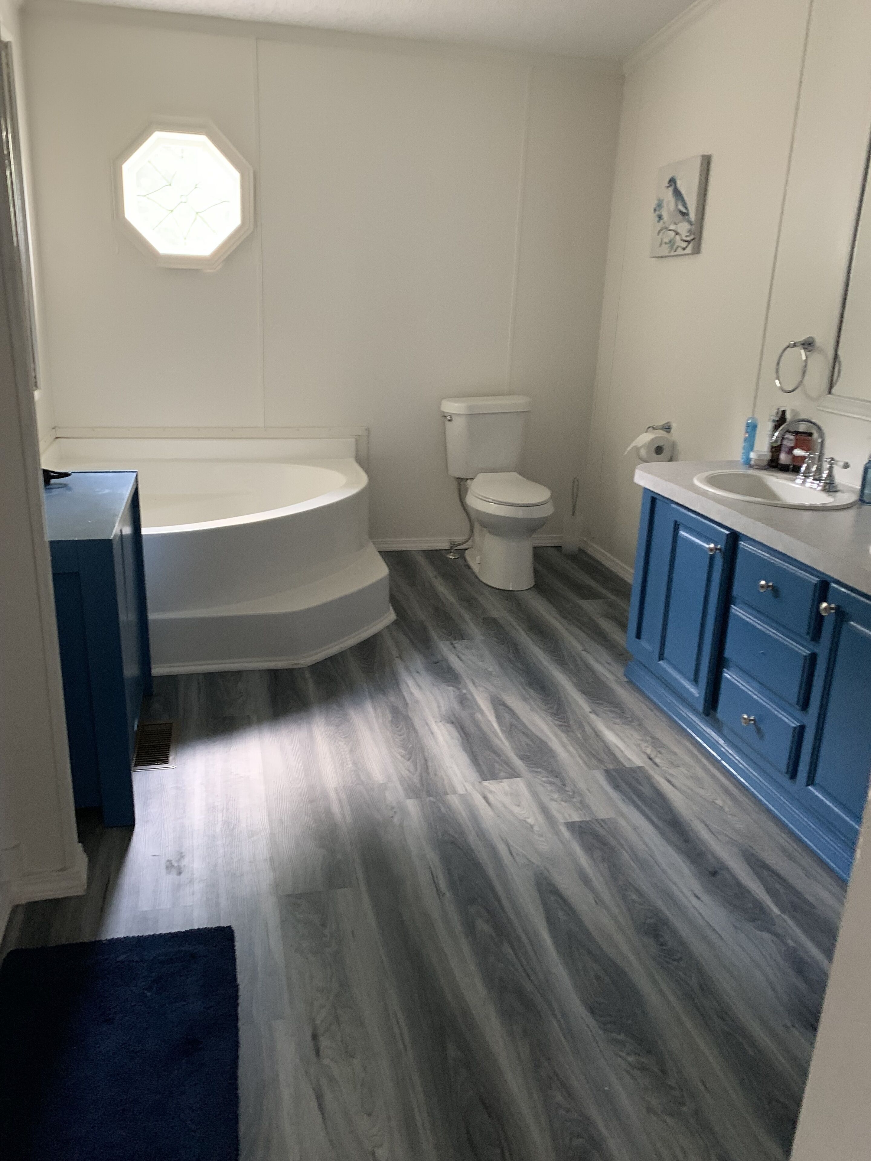 Un baño con bañera, inodoro y tocador con lavabo.