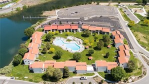 An aerial view of a resort with a central swimming pool, connected buildings, and a parking area. - Condo in Crescent Bar Resort—20 minutes from the Gorge amphitheater. (Quincy)