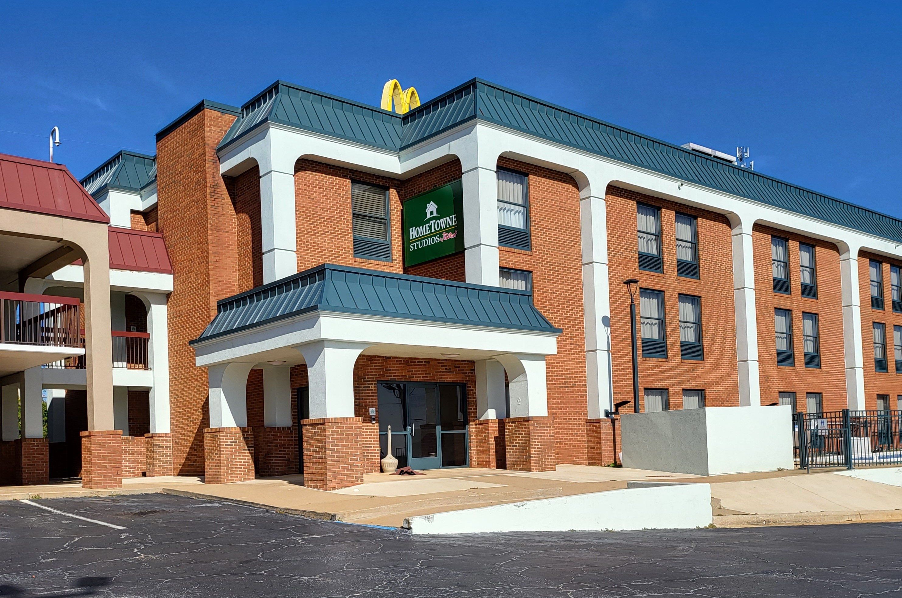 Un edificio de varios pisos con un letrero verde que dice 'Home Towne Studios'.