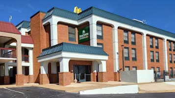 Un edificio de varios pisos con un letrero verde que dice 'Home Towne Studios'.