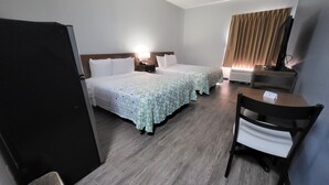 A hotel room with two beds, a desk, a chair, a TV, and a waste bin. - HomeTowne Studios by Red Roof Prattville (Prattville)