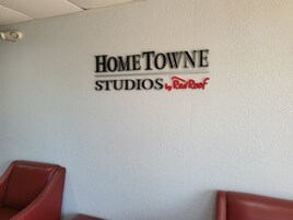 Una pared con el texto 'HOME TOWNE STUDIOS by Red Roof' y dos sillas rojas.