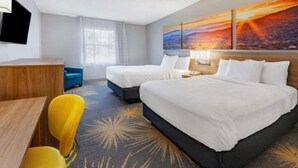 A hotel room with two beds, a desk, a chair, and a TV. - Deluxe Double Room with Two Double Beds - Non-Smoking (Roanoke)