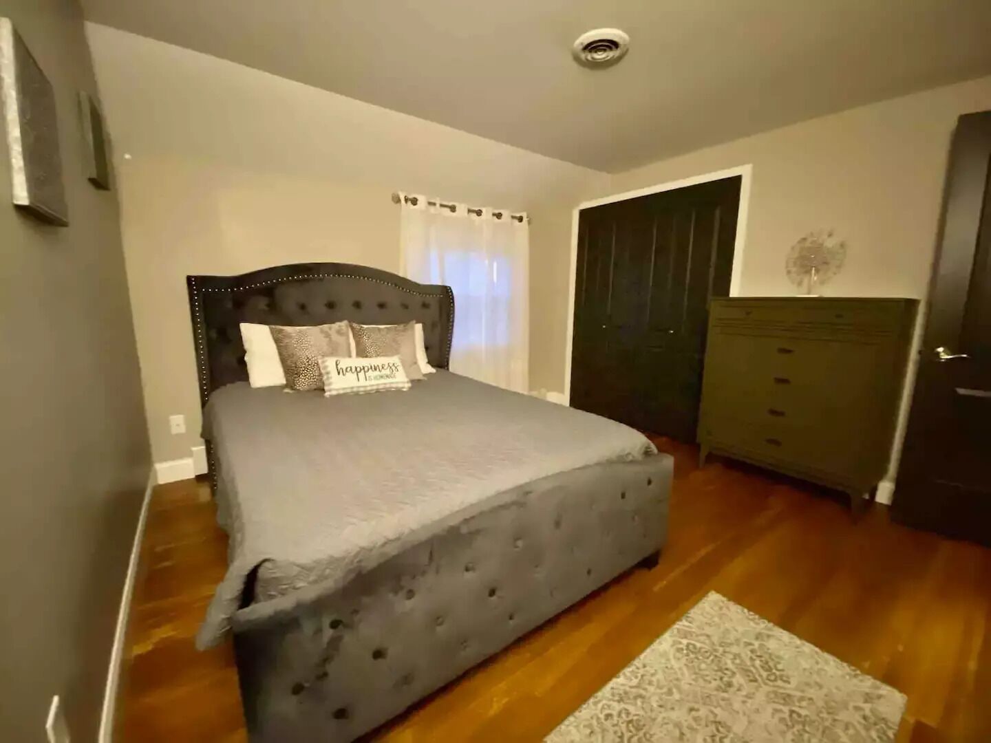 Un dormitorio con una cama grande, un aparador y una puerta.