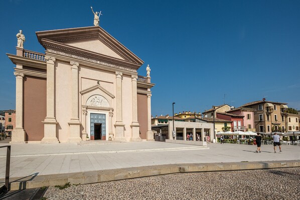 A historic building with classical architecture, a central entrance, and statues on the roof. - Near Gardaland, 2 minutes from the lake, in the heart of Peschiera del Garda! Xenia19 (Peschiera del Garda)