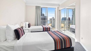 A hotel room with two beds, a balcony with a city view, and a large window. - Chevron Renaissance Ocean View (Surfers Paradise)
