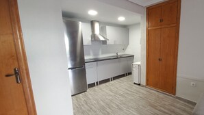 Una cucina moderna con elettrodomestici in acciaio inox, mobili in legno e forno integrato.