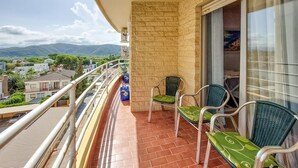 A balcony with two chairs, a view of the city, and a mountain in the background. - Gorgeous apartment in Grau i Platja with WiFi (Grau i Platja)