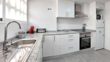 Een koelkast, een oven, een kookplaat, een koffiezetapparaat/waterkoker