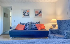Relax in a stylish living room with a sofa, armchair, and abstract art pieces.