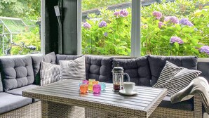 Un coin salon confortable avec un canapé moelleux, une table en bois et de la verrerie aux couleurs vives.
