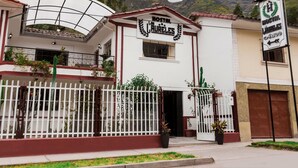 Un hotel con un letrero que dice "HOTEL LA FURLALES" y un letrero de hostal cerca.