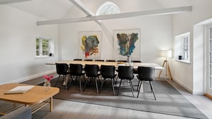 A conference room with a long table, black chairs, and two abstract paintings on the walls. - 4 bedroom lovely home in Næstved (Næstved)