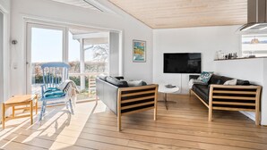 A modern living room with a wooden floor, two sofas, a TV, and a large window. - Amazing home in Samsø with Wi-Fi (Samsø)