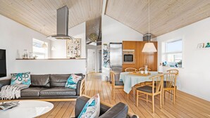 A modern living room with a sofa, coffee table, and dining area with chairs and a table. - Amazing home in Samsø with Wi-Fi (Samsø)
