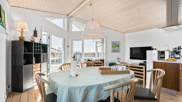 A spacious dining area with a round table, wooden chairs, and a ceiling with exposed beams. - Amazing home in Samsø with Wi-Fi (Samsø)