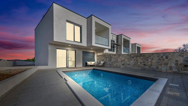 A modern two-story house with a swimming pool, stone wall, and a patio with outdoor furniture. - Beach front home in Vodice (Vodice)